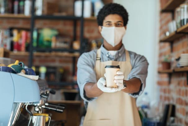 Barista with coffee wearing mask
